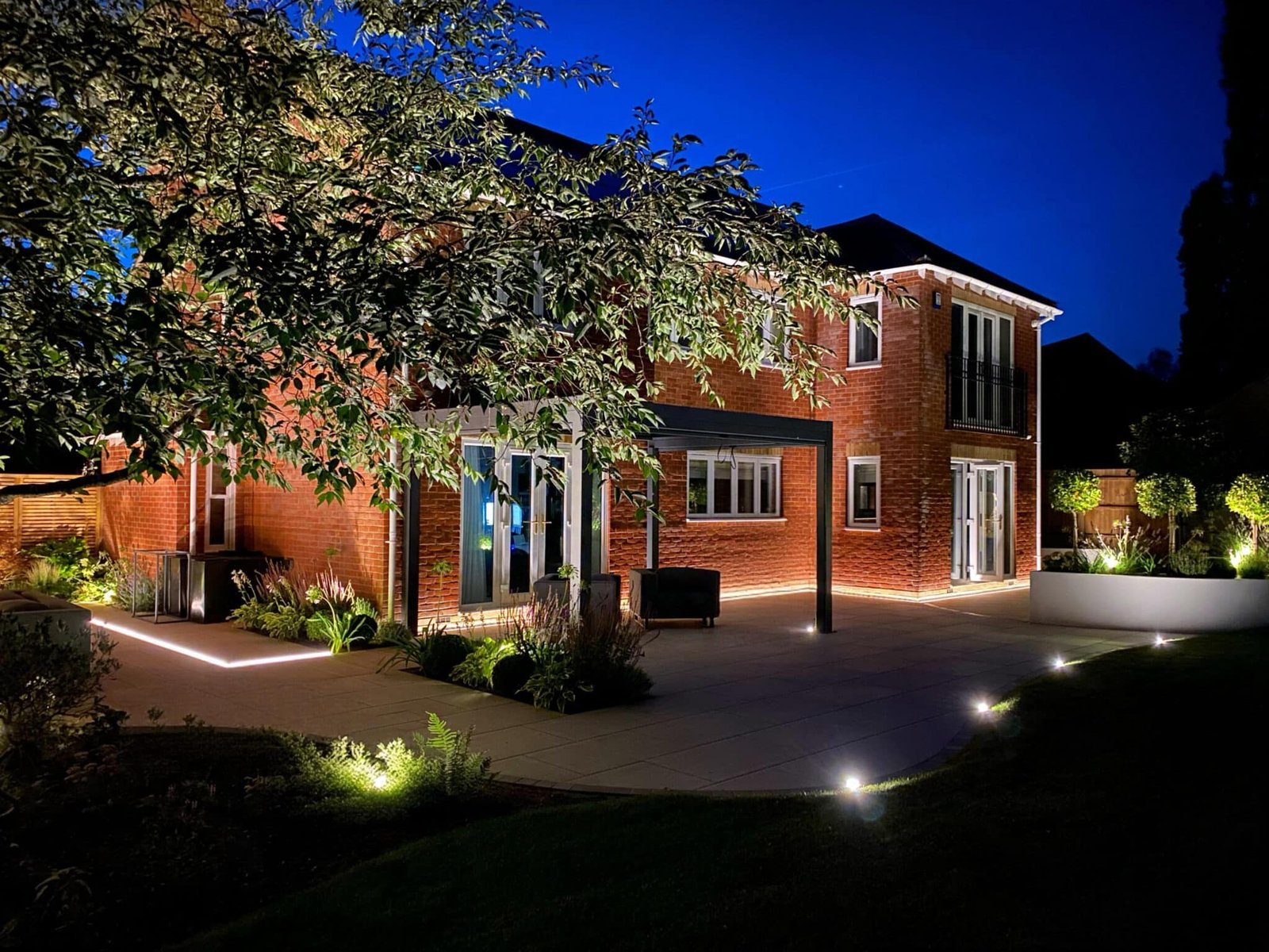 Illuminated garden and paving by EH Landscapes after dark